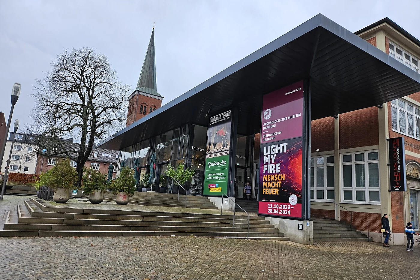 Theatergebäude mit Plakatwänden am gepflasterten Platz