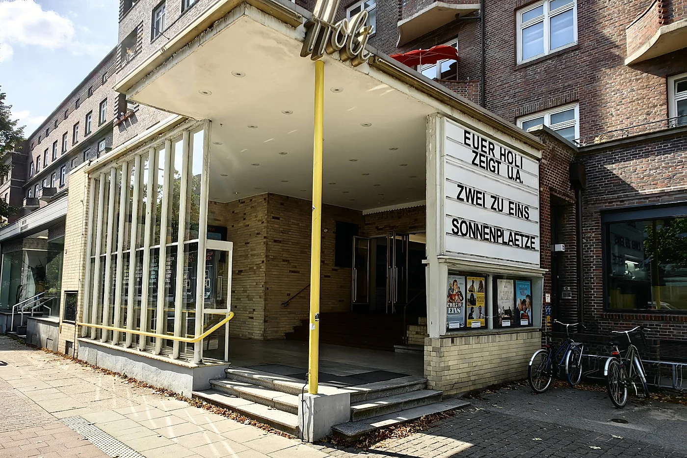 Kinoeingang mit weit auskragendem Vordach, Neonschriftzug Holi und Schaukasten mit Steckbuchstaben