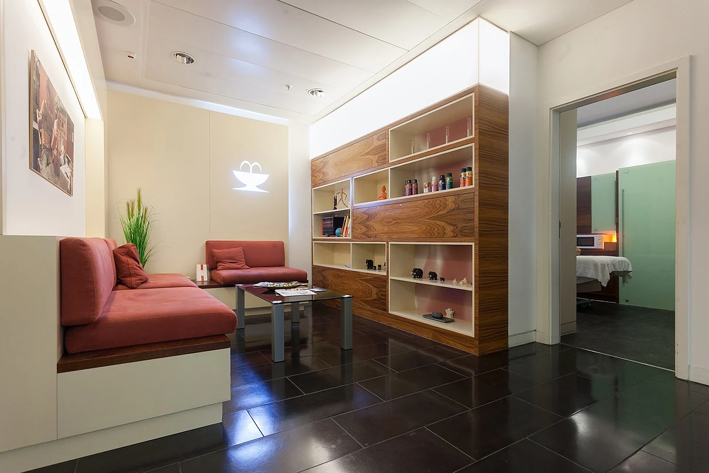 Loungebereich mit Sitzbank, Regalwand und Leuchte
