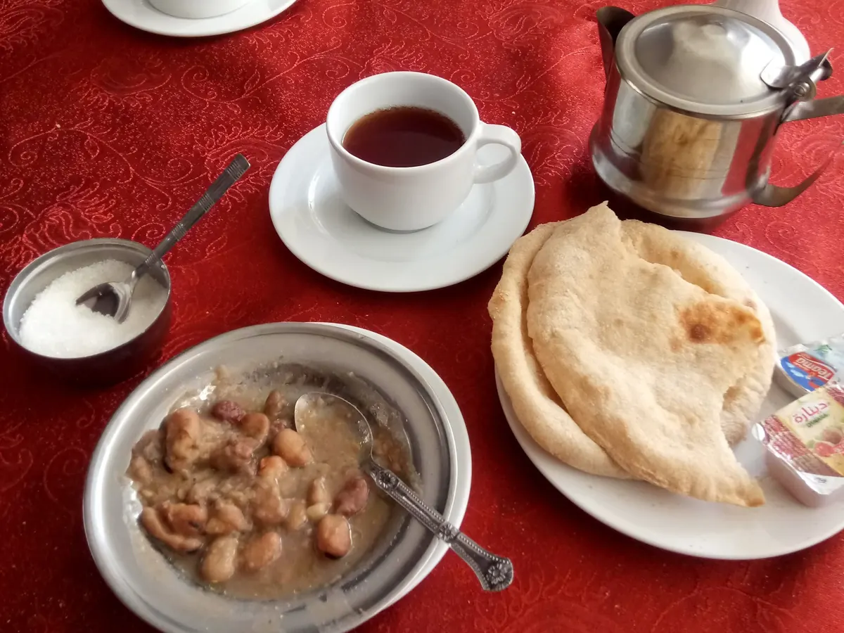 Gedeckter Tisch mit Saubohnen, Fladenbrot und einer Tasse Tee