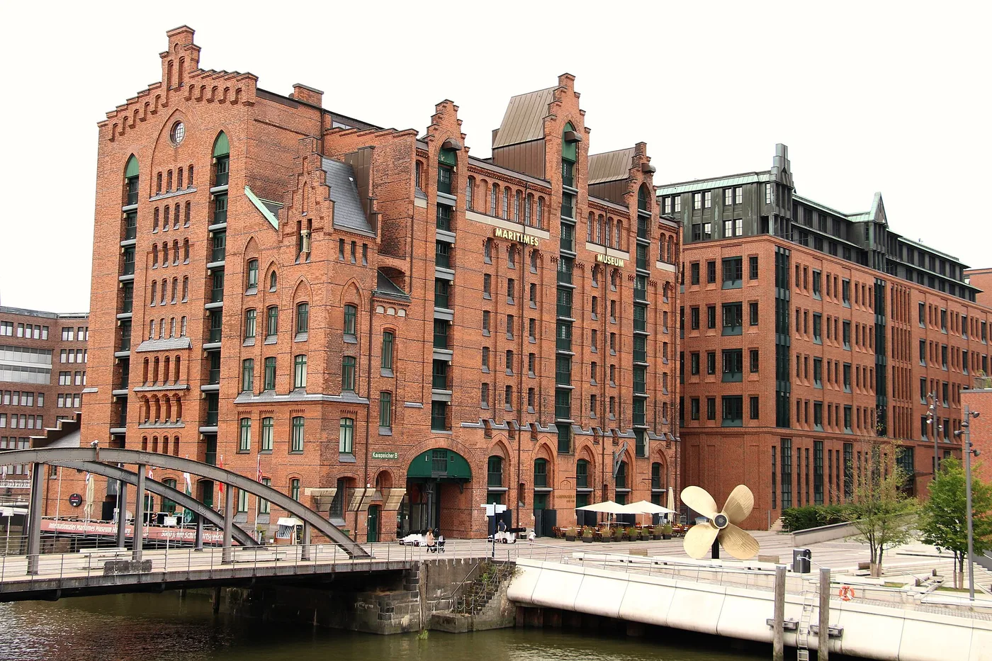 Kaispeicher B in der Hamburger HafenCity mit dem Schriftzug Maritimes Museum und goldener Schiffsschraube davor