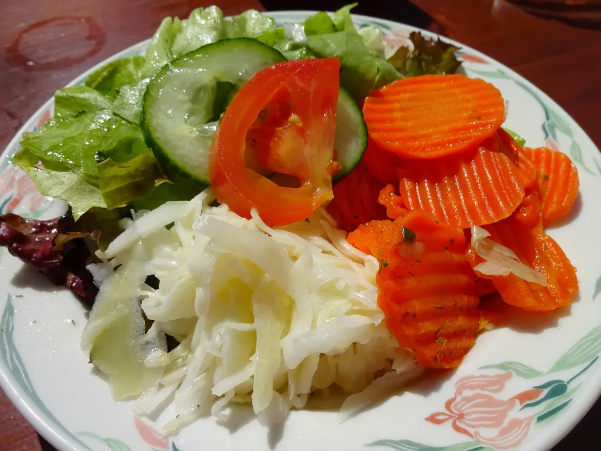 Gemischter Beilagensalat mit Blattsalat, Gurke, Tomate, Karotten und Krautsalat