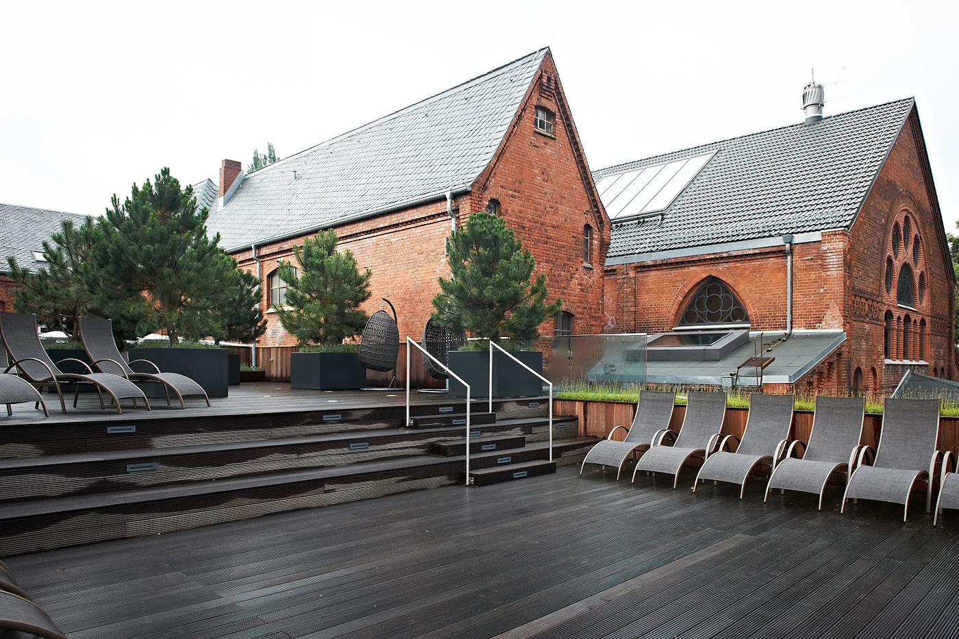 Terrasse mit Liegestühlen vor dem Backsteingebäude