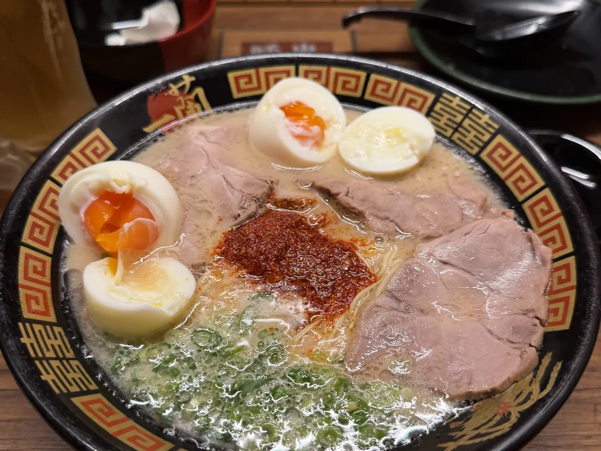 Schale Ramen mit Schweinefleisch, halbiertem Ei und Frühlingszwiebeln in heller Brühe