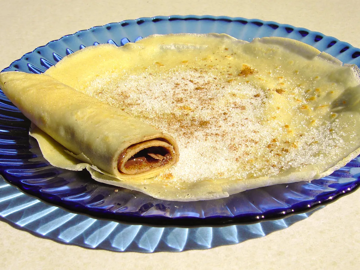 Crêpe mit Zimt und Zucker auf einem blauen Teller