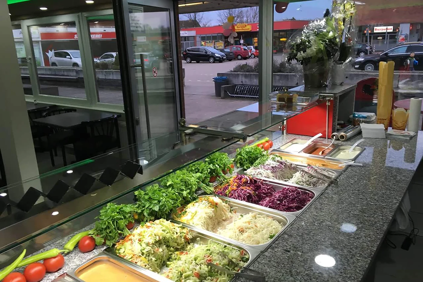Theke mit Salaten und Gemüse in Edelstahlbehältern