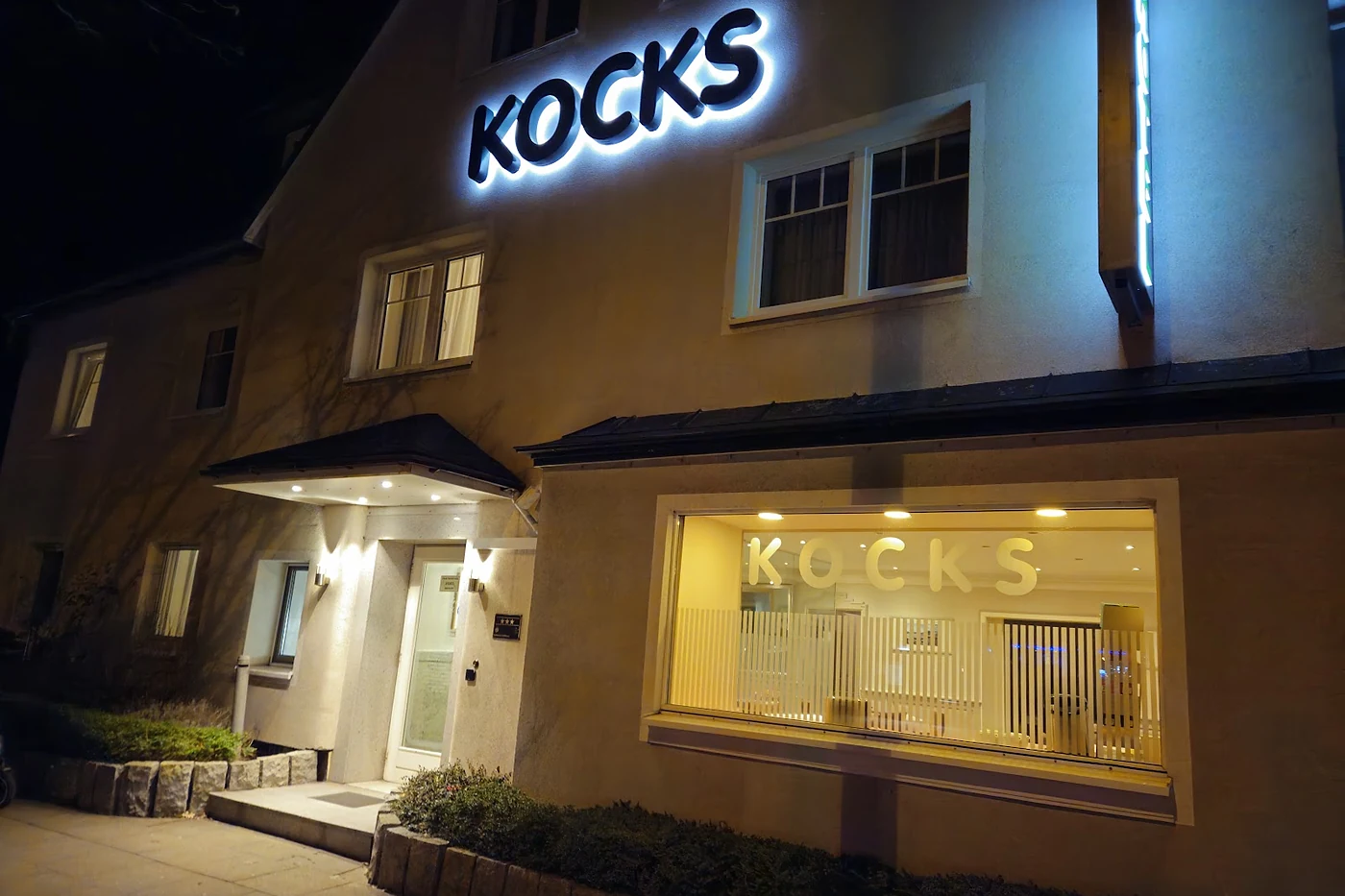 Beleuchteter Namenszug des Hotels bei Nacht