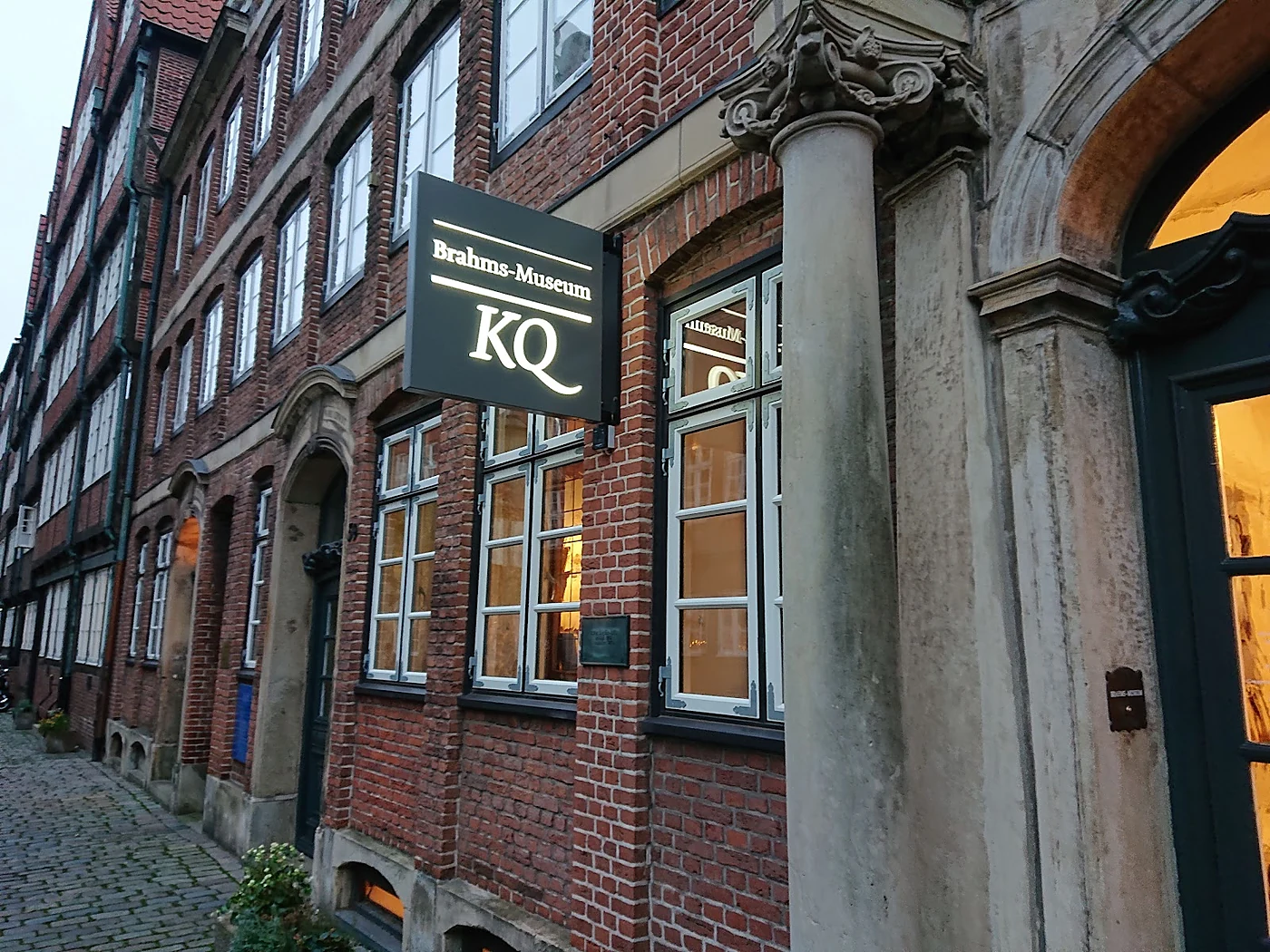 Schild „Brahms-Museum KQ“ an der Backsteinfassade in der Peterstraße, daneben ein barockes Sandsteinportal