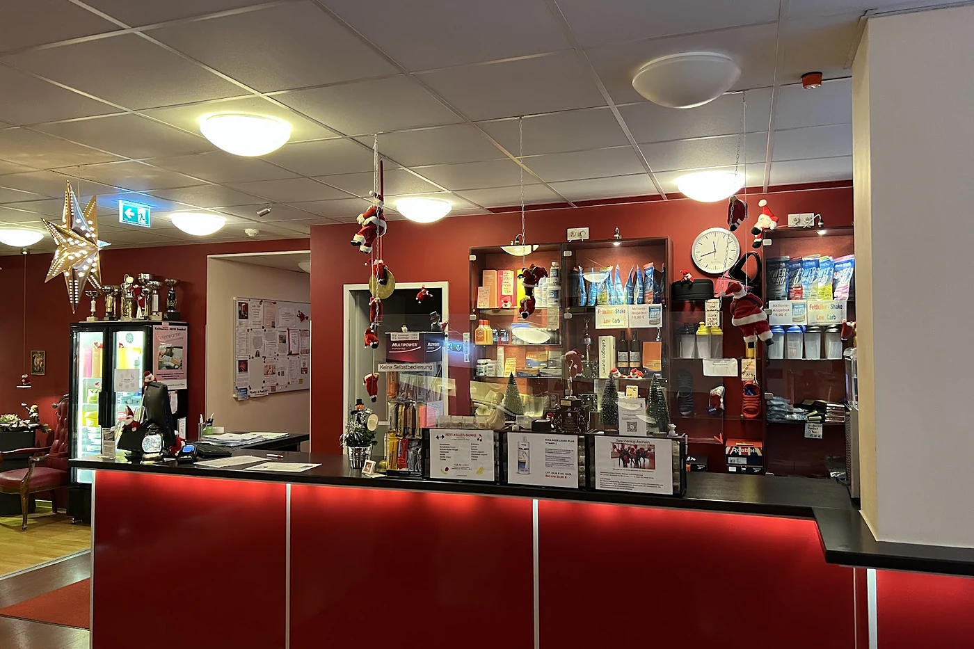 Roter Empfangstresen mit Regalwand dahinter