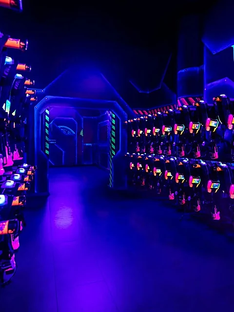 Reihen von Lasertag-Westen mit leuchtenden Sensoren in einem blau beleuchteten Gang
