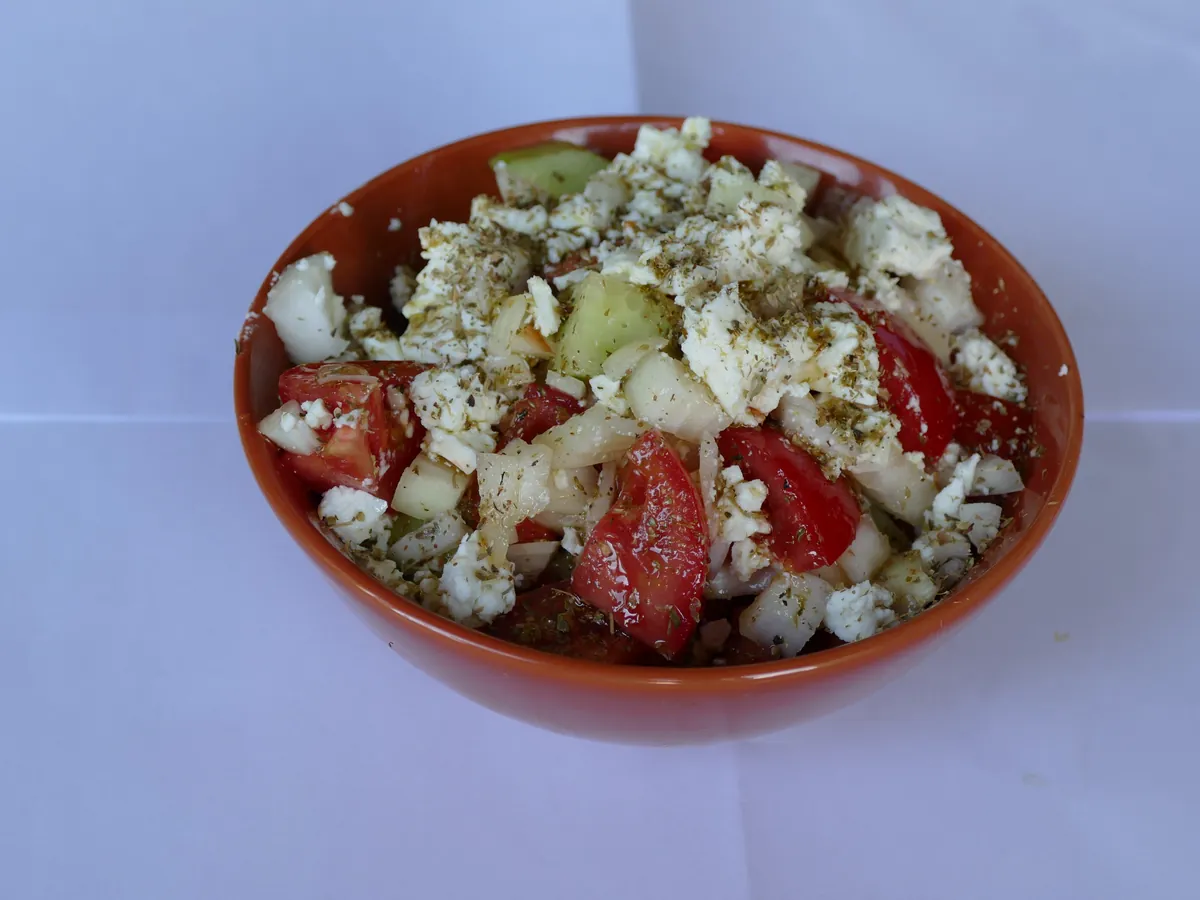 Griechischer Salat mit Tomaten, Gurke, Zwiebeln und Feta in einer Tonschale
