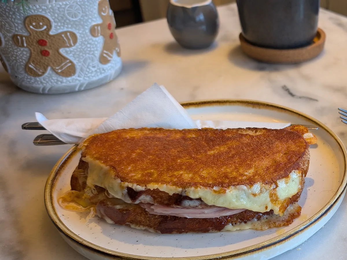 Überbackener Croque mit Schinken und geschmolzenem Käse auf einem Teller