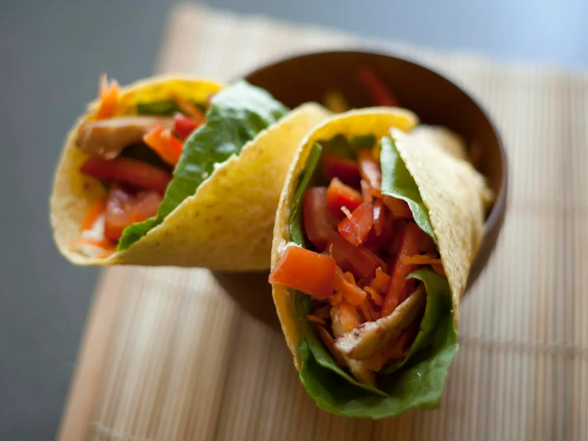 Zwei gefüllte Wraps mit Hähnchen, Paprika, Tomaten und Salat