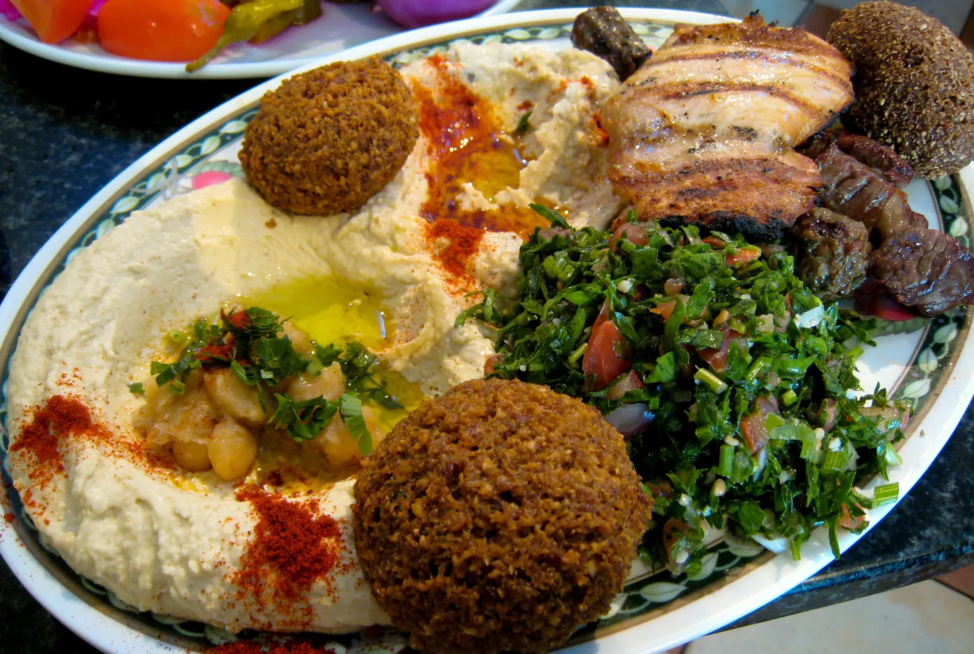 Platte mit Hummus, Falafel, Tabbouleh und gegrilltem Fleisch