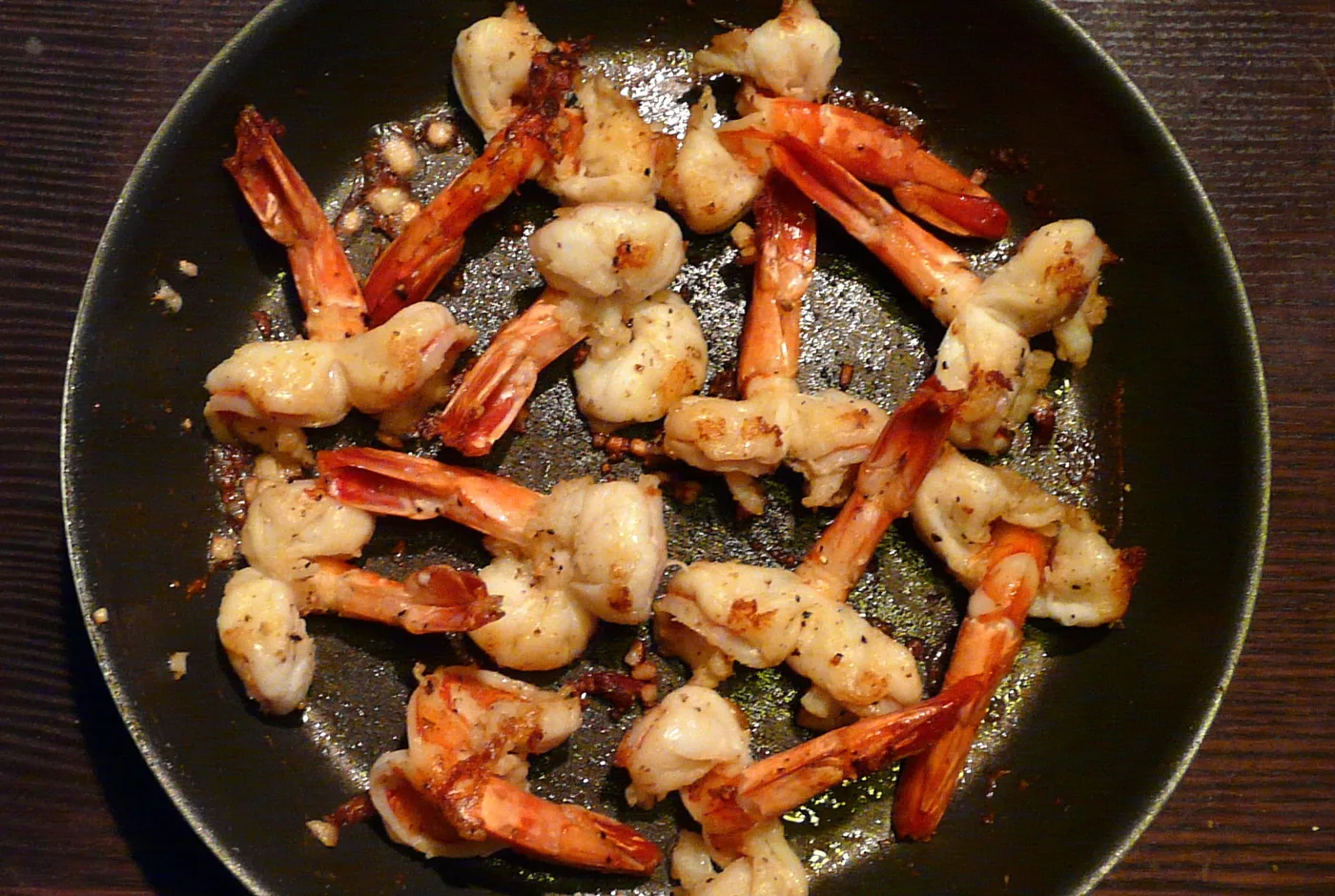 Gebratene Garnelen mit Knoblauch in einer schwarzen Pfanne