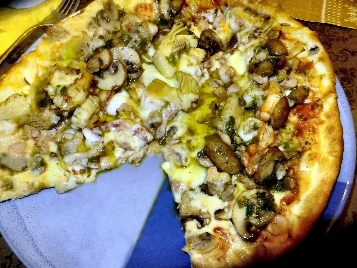 Pizza mit Muscheln, Garnelen und Tintenfisch auf einem Teller