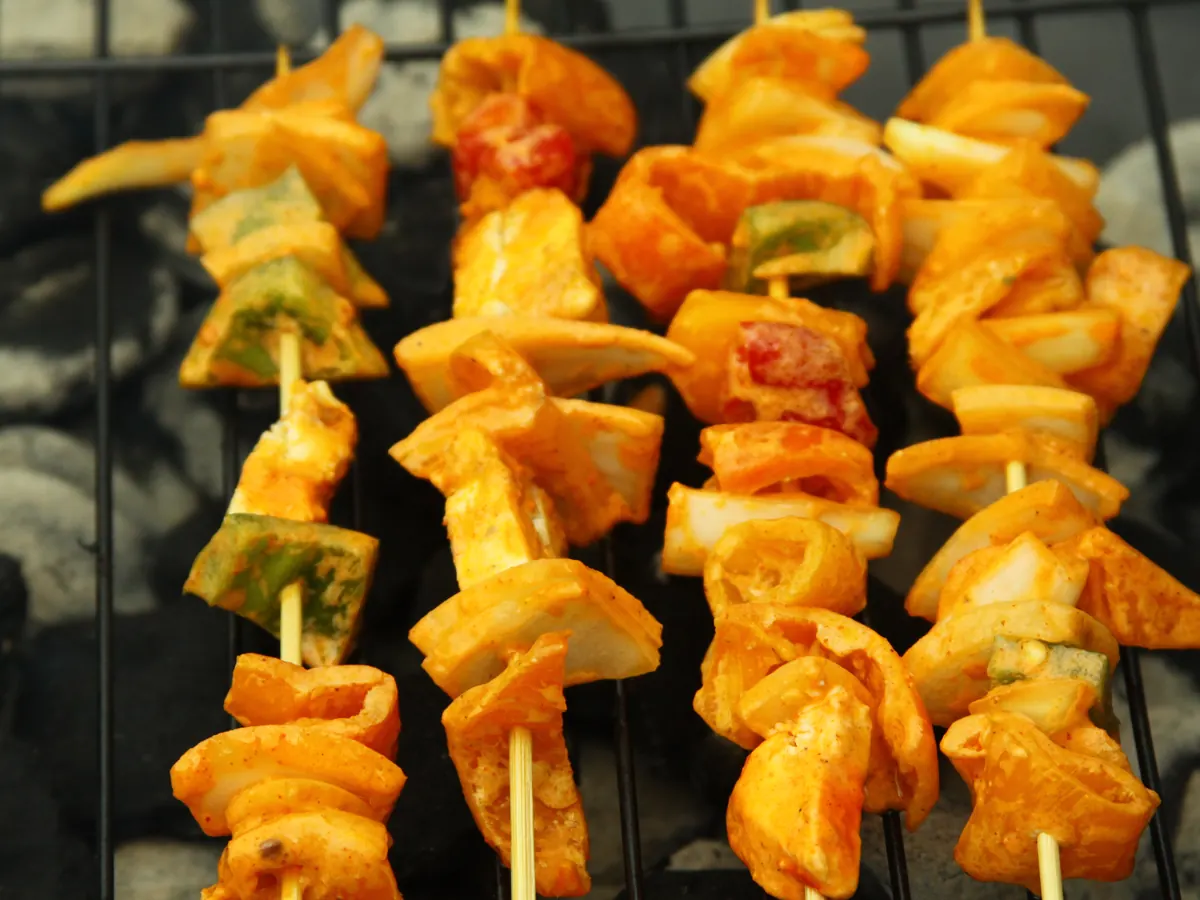 Spieße mit mariniertem Paneer und Paprika auf einem Grillrost