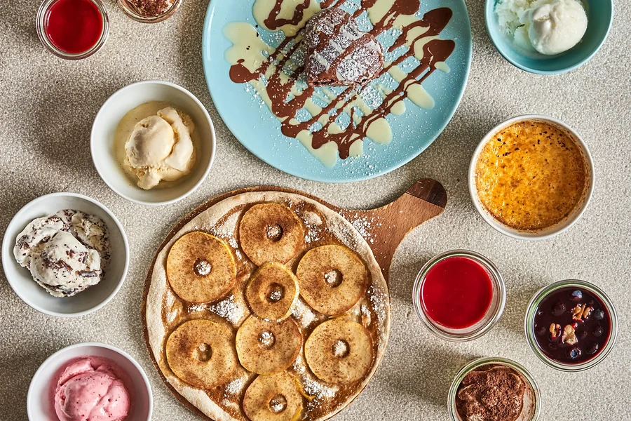 Dessertauswahl mit Apfelkuchen, Eis, Schokoladensauce und Sorbets von oben