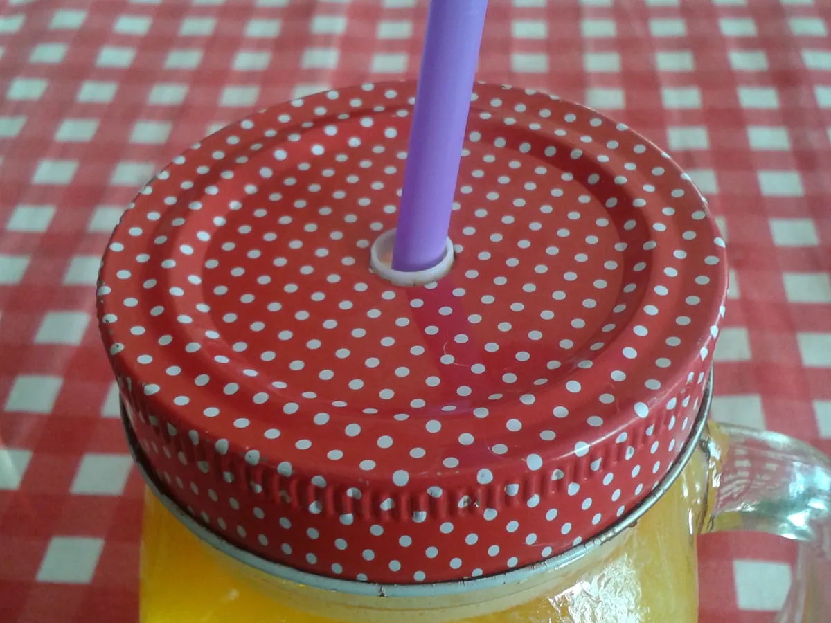 Glas mit frisch gepresstem Orangensaft neben halbierten Orangen