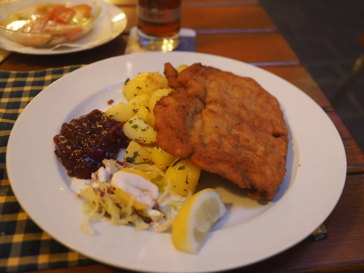 Paniertes Schnitzel mit Petersilienkartoffeln, Preiselbeeren, Salat und einer Zitronenspalte