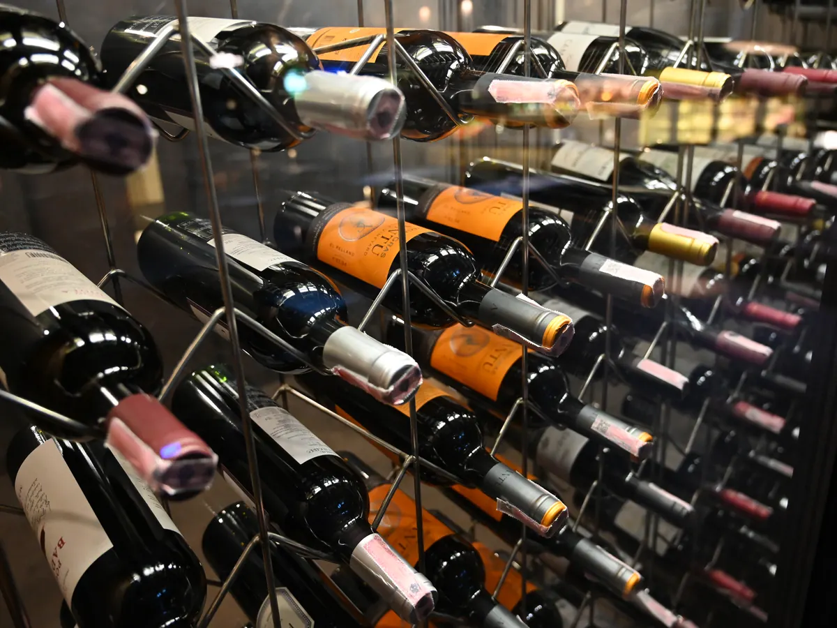 Weinregal mit liegenden Flaschen im gedämpften Licht eines Kellers