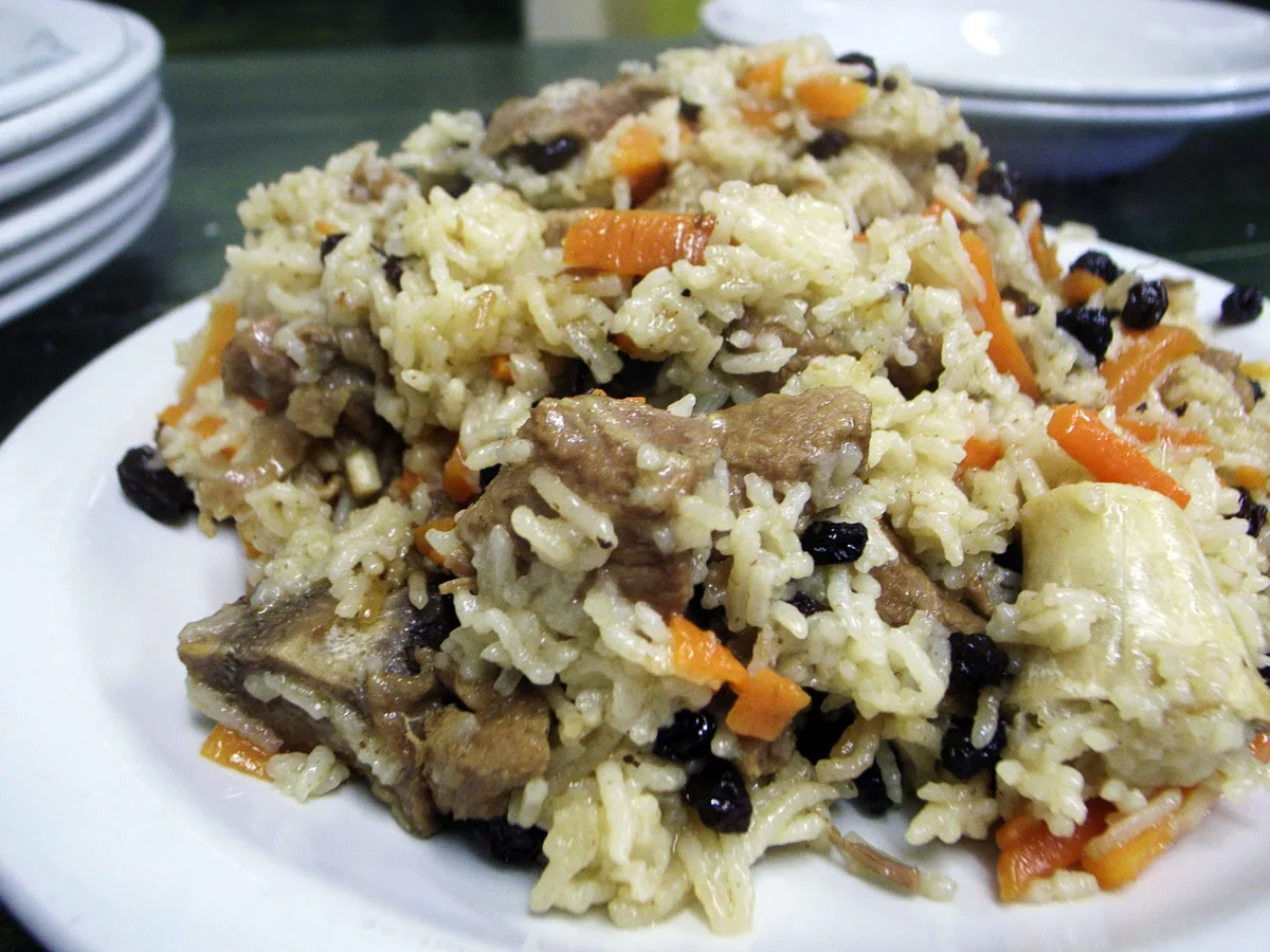 Teller mit Qabeli-Reis, Karotten, Rosinen und Lammfleisch