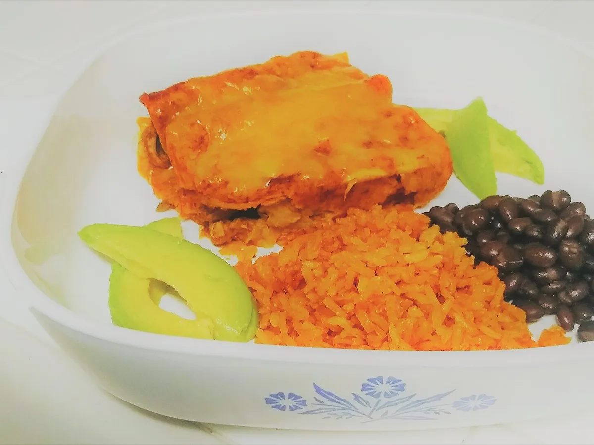Enchiladas mit roter Sauce und Käse überbacken, dazu Reis, schwarze Bohnen und Avocado