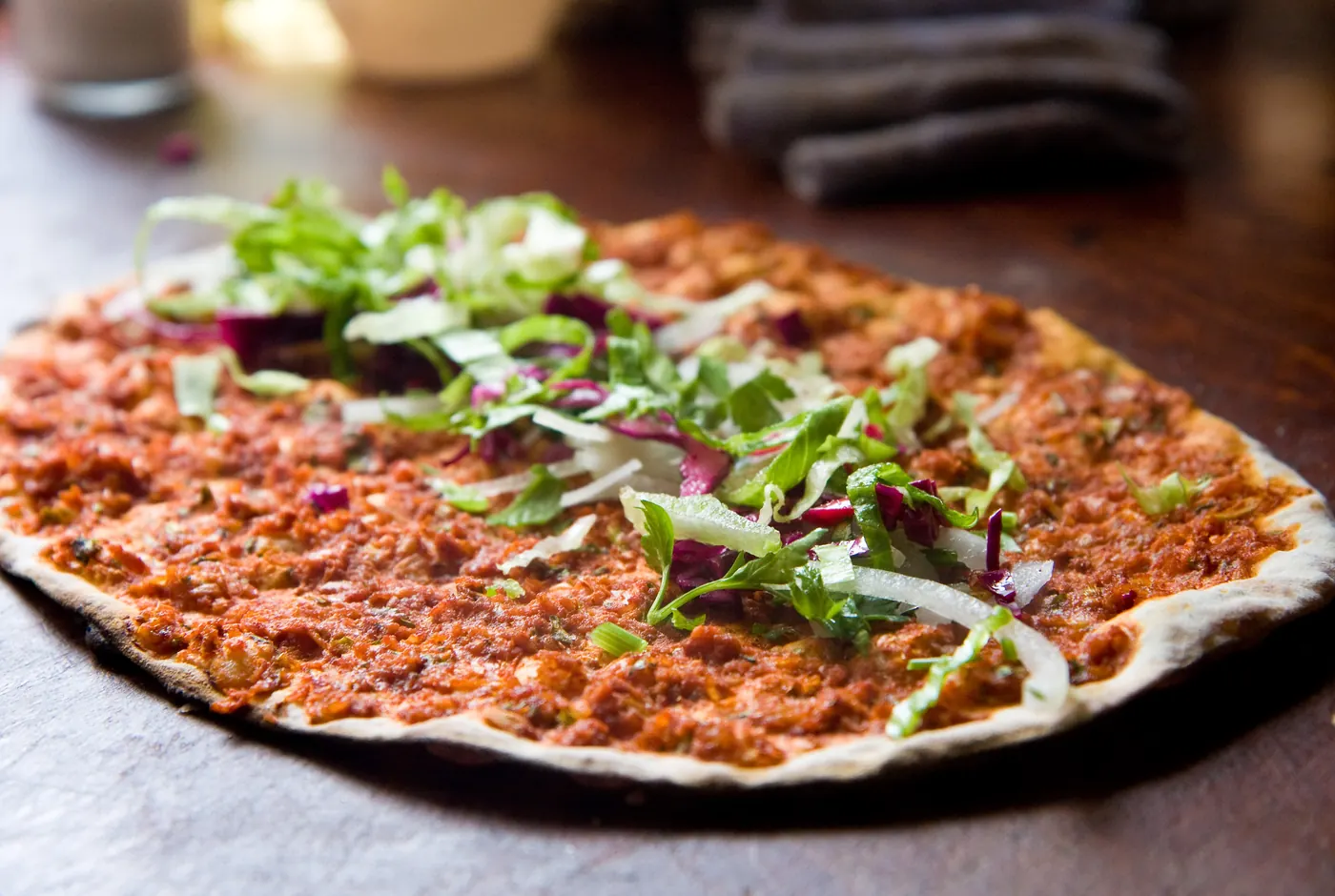 Lahmacun mit würziger Hackfleischauflage, belegt mit Salat, Zwiebeln und Rotkohl