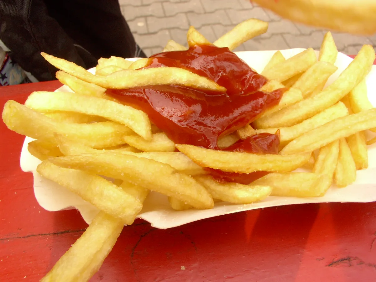 Portion Pommes frites mit Ketchup in einer Pappschale