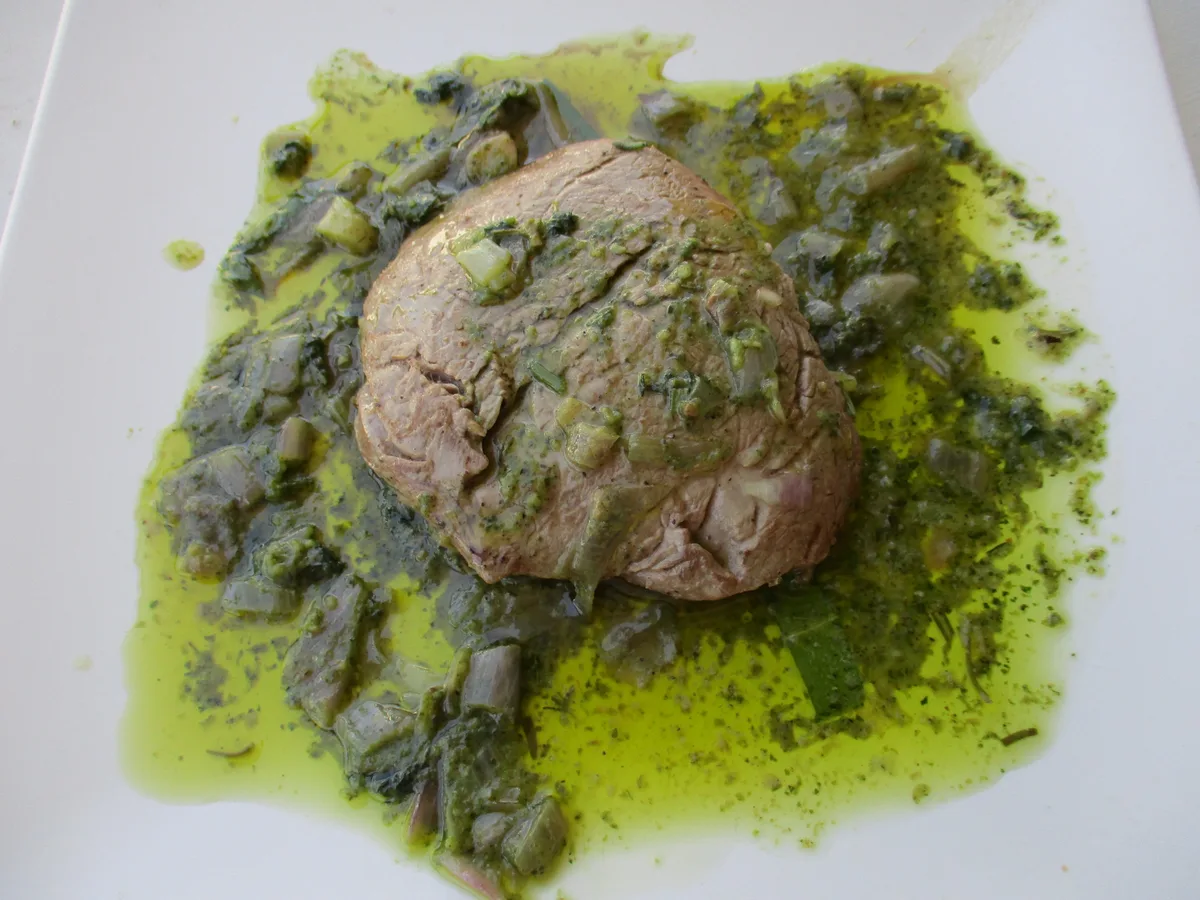 Rinderfilet in grüner Kräutersauce, angerichtet auf einem weißen Teller
