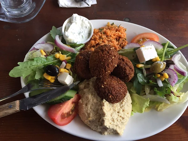 Falafelteller mit Hummus, Bulgursalat, Tzatziki, Feta und Salat