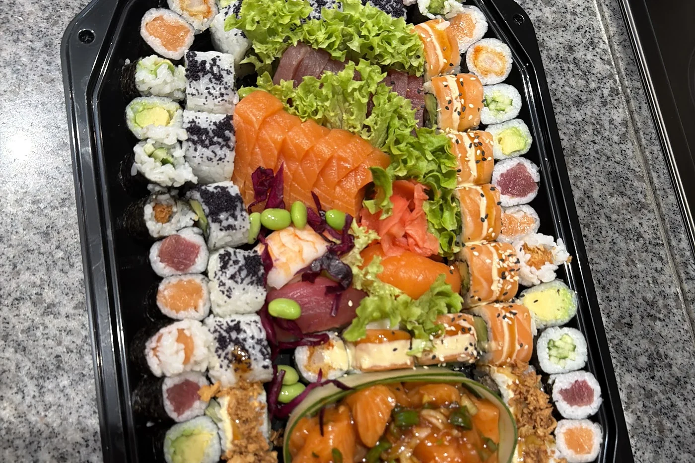 Ovale Platte mit Sushi-Rollen und Garnitur