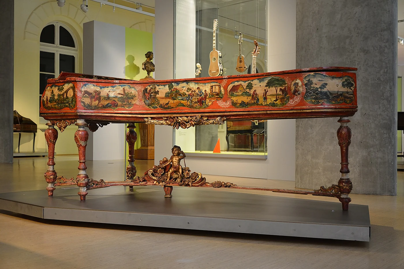Bemaltes historisches Cembalo mit vergoldeten Füßen und Putto in der Musikinstrumentensammlung des Museums für Kunst und