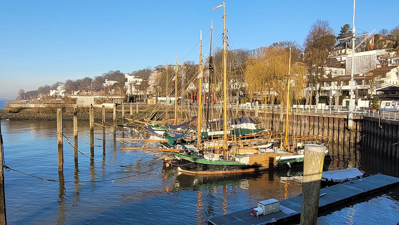 Historische Segelschiffe mit hohen Masten am Ponton des Museumshafens, dahinter die Villen am Elbhang von Övelgönne