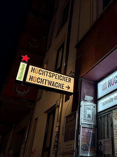 Beleuchtetes Wegweiserschild Nochtspeicher Nochtwache mit Pfeil an der Bernhard-Nocht-Straße bei Nacht