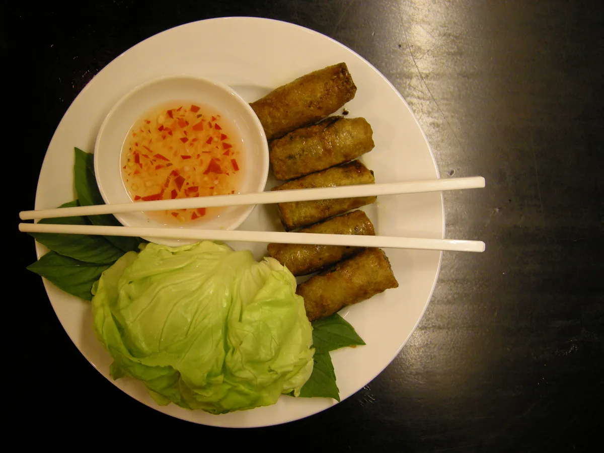 Knusprige vietnamesische Frühlingsrollen mit Chili-Dip, Salat und Basilikum