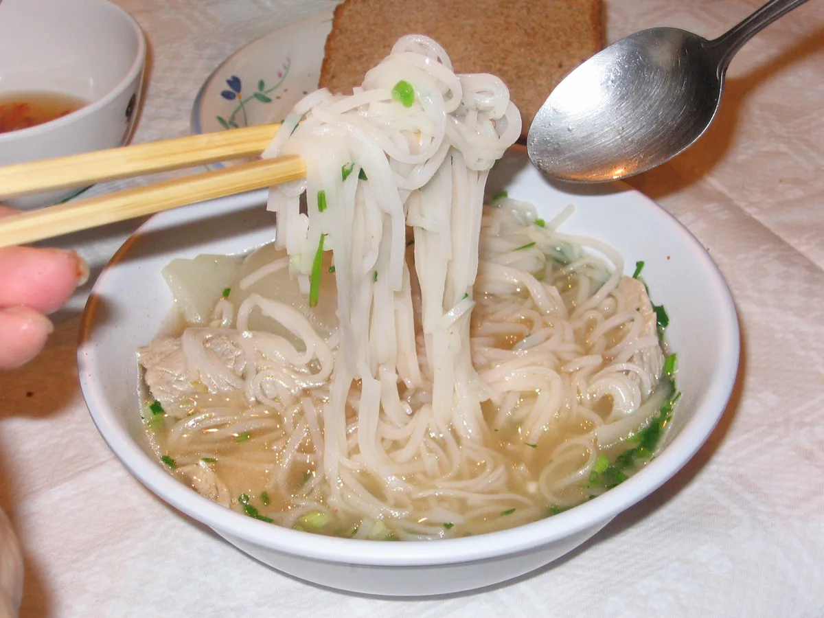 Schüssel Pho mit Reisnudeln, Rindfleisch und frischen Kräutern
