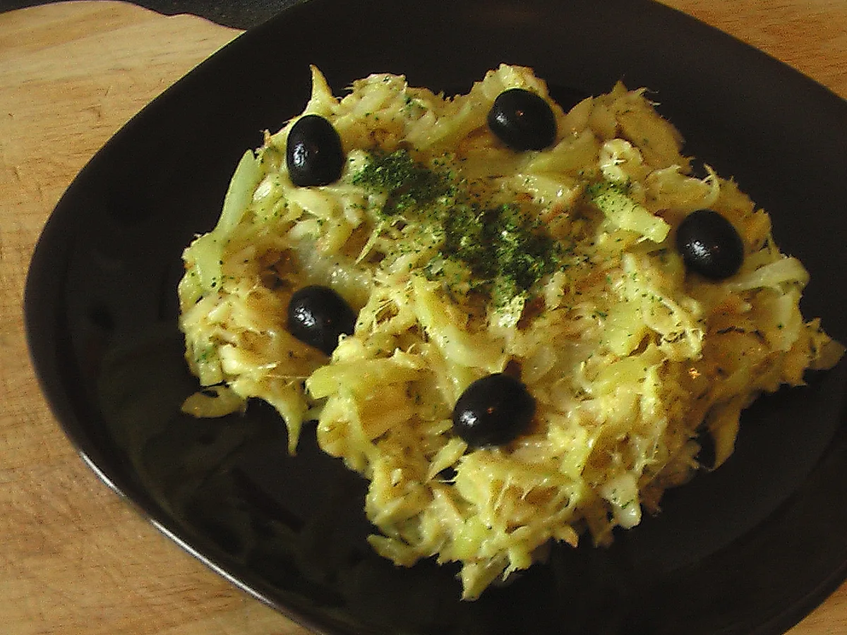 Bacalhau à Brás, zerzupfter Stockfisch mit Ei, Kartoffelstreifen und schwarzen Oliven