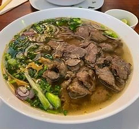 Phở mit Rindfleisch, Reisbandnudeln, roten Zwiebeln und frischen Kräutern