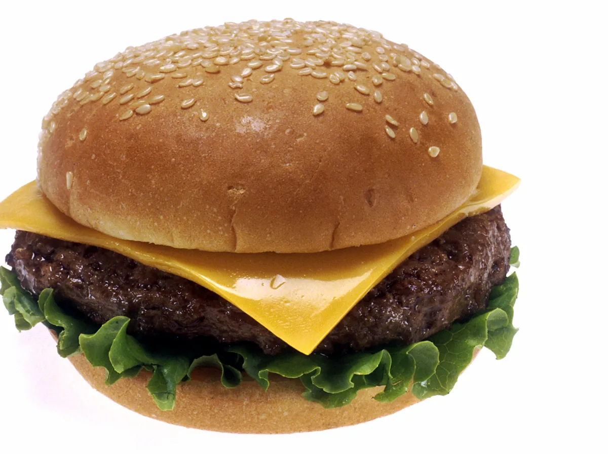 Klassischer Cheeseburger mit Salat, Käse und Sesambrötchen