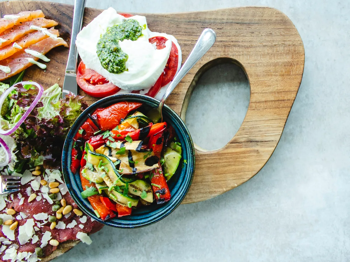 Vorspeisenteller mit Burrata, geröstetem Gemüse und Räucherlachs