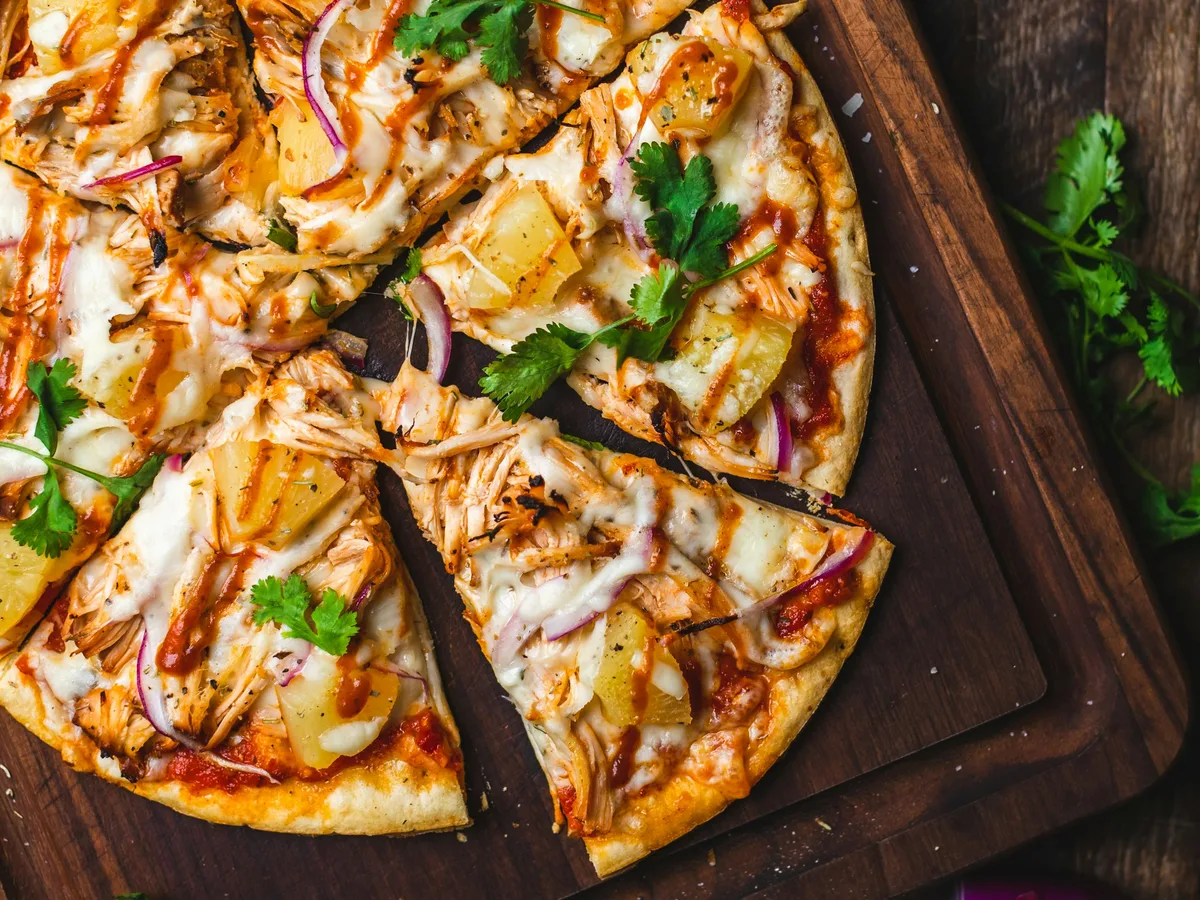 Pizza mit Käse und Kräutern, in Stücke geschnitten