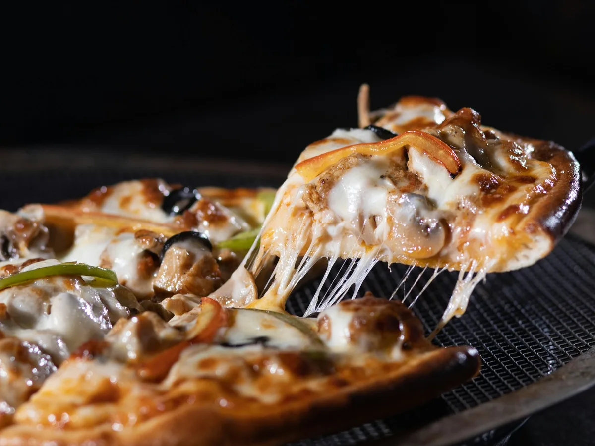Pizzastück wird mit einem Pizzaheber angehoben