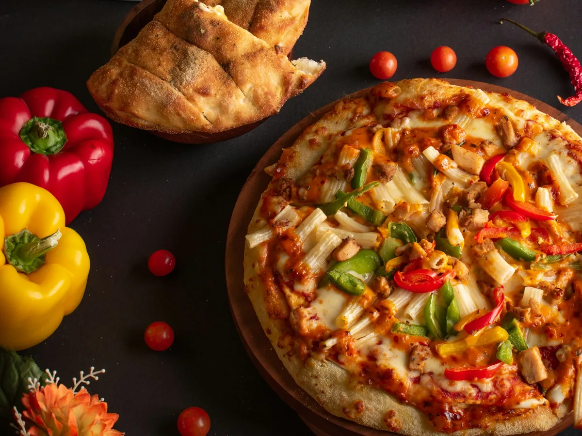 Pizza mit Tomaten und Käse auf Holzunterlage