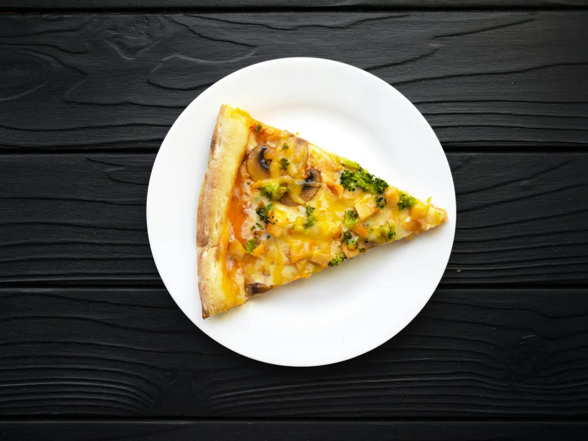 Pizzastück auf einem weißen Teller