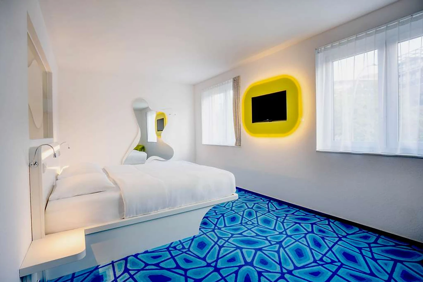 Zimmer mit blauem Teppich und gelbem Fernsehrahmen