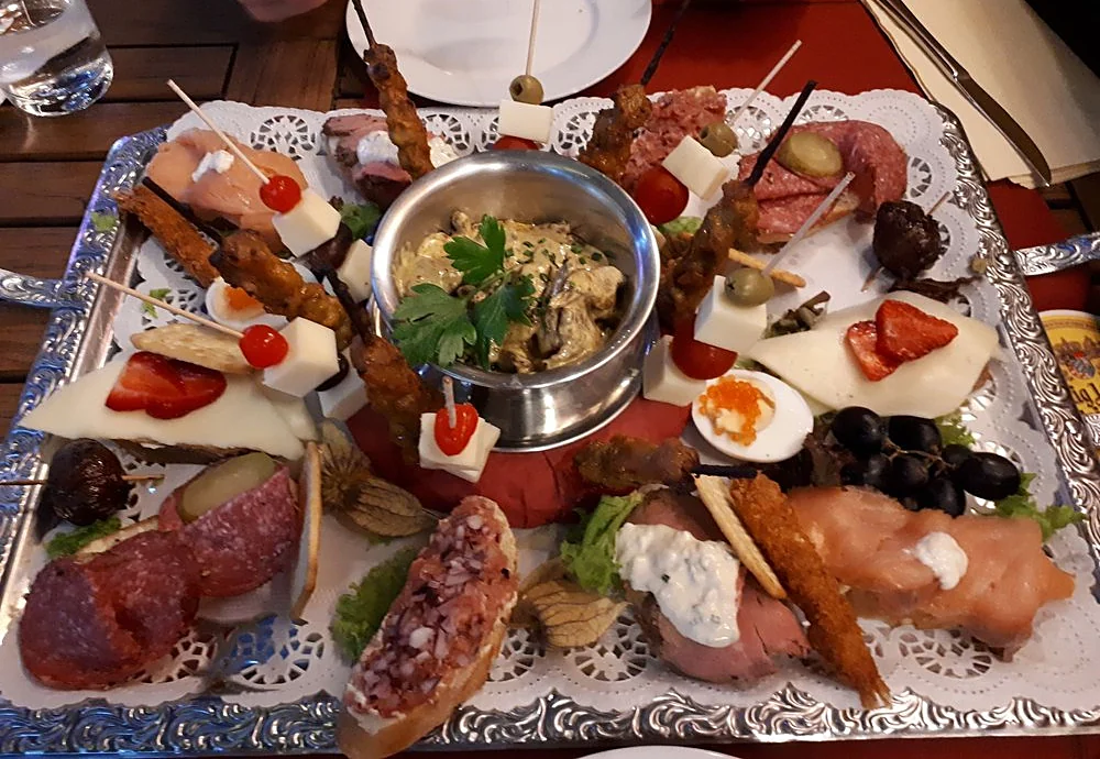 Große Vorspeisenplatte mit Spießen, Käsewürfeln, Salami, Lachsröllchen, Roastbeef und Dip in Silberschale
