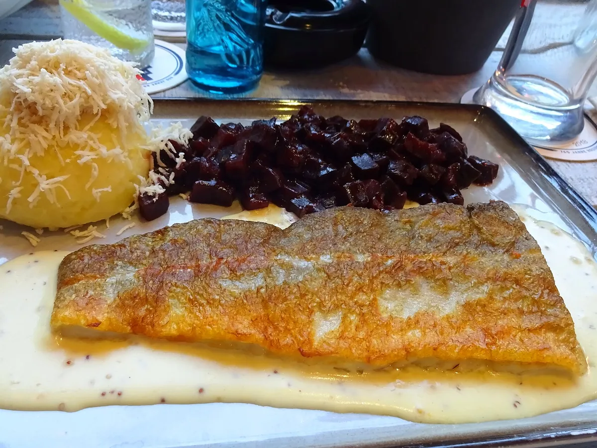 Gebratenes Dorschfilet mit heller Sauce, Kartoffel und roter Bete auf einem Teller