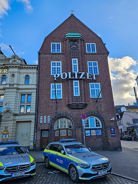 Backsteinfassade der Davidwache mit Polizei-Schriftzug und zwei Streifenwagen davor