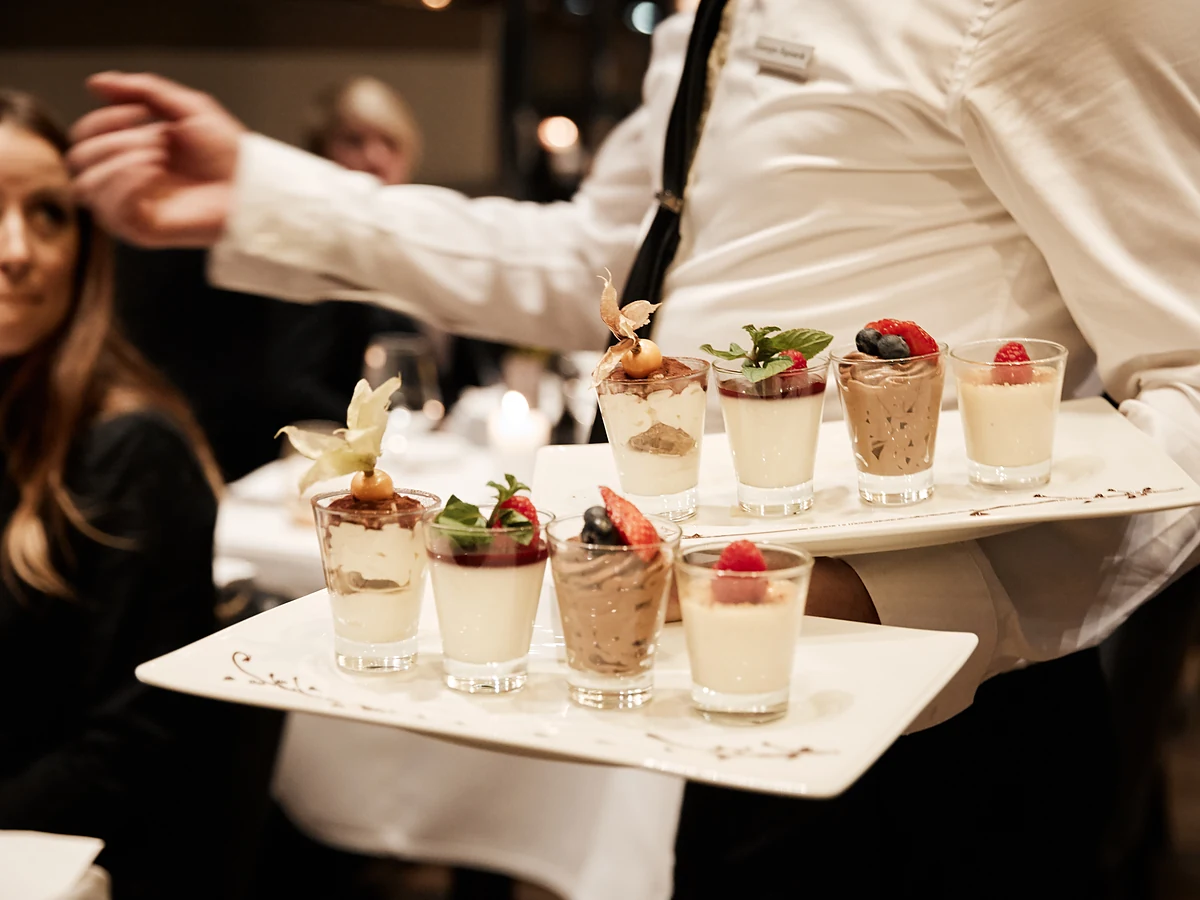 Etagere mit kleinen Speisen wird von einer Servicekraft getragen